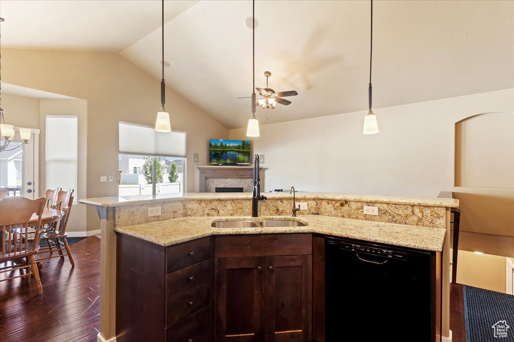 Kitchen with dishwasher, dark wood finished floors, lofted ceiling, a ceiling fan, and a fireplace