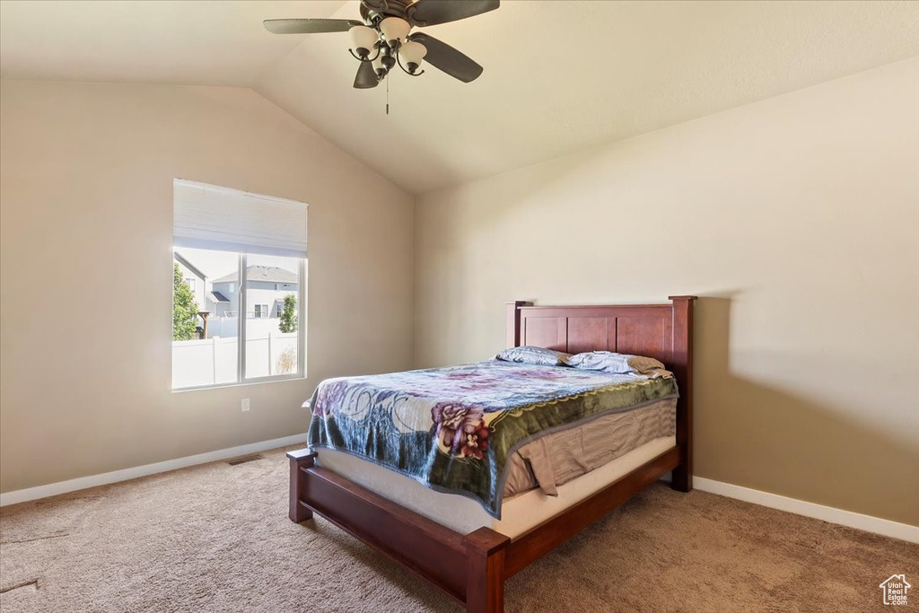 Bedroom featuring vaulted ceiling, carpet, baseboards, and a ceiling fan
