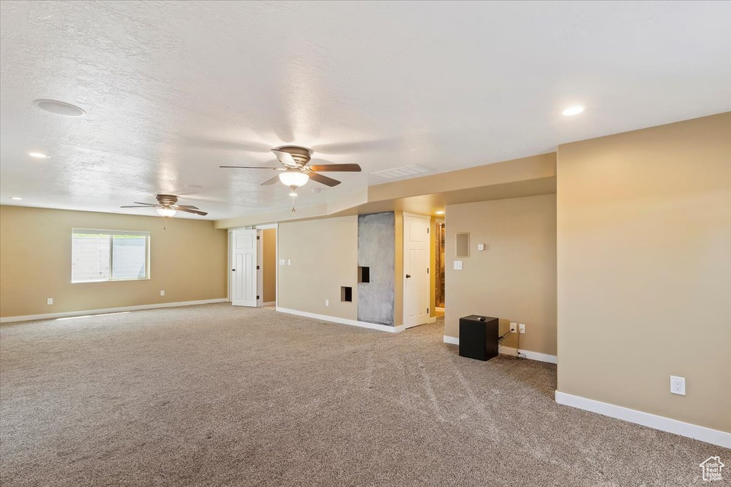 Empty room featuring light carpet, ceiling fan, baseboards, and recessed lighting