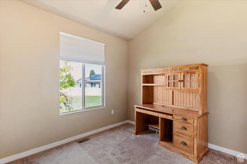Unfurnished office with ceiling fan, light carpet, baseboards, and lofted ceiling