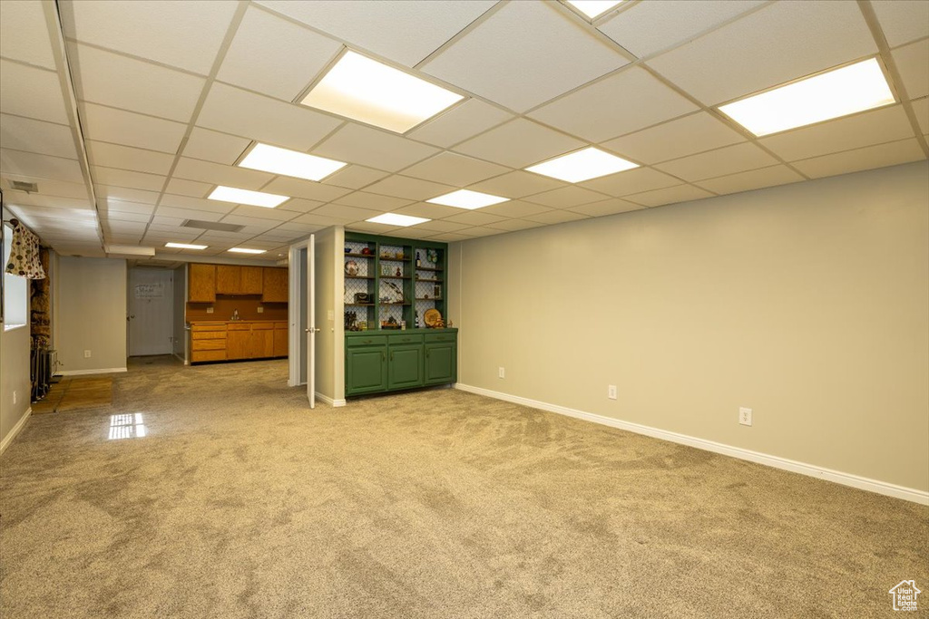 Unfurnished room with light colored carpet, baseboards, and a paneled ceiling
