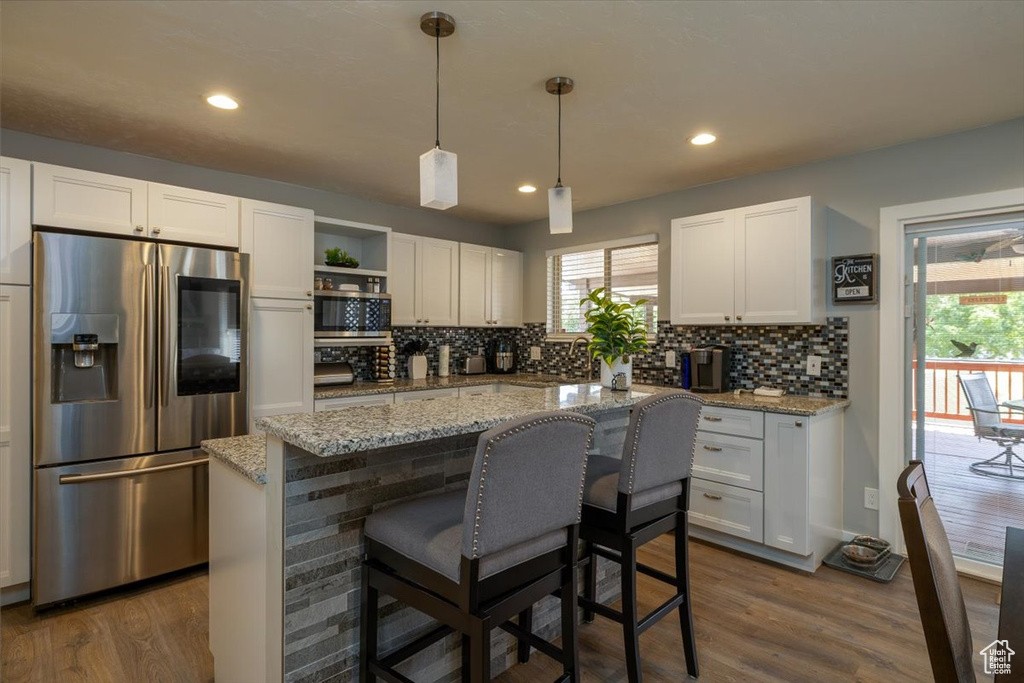 Kitchen with appliances with stainless steel finishes, white cabinetry, backsplash, open shelves, and recessed lighting