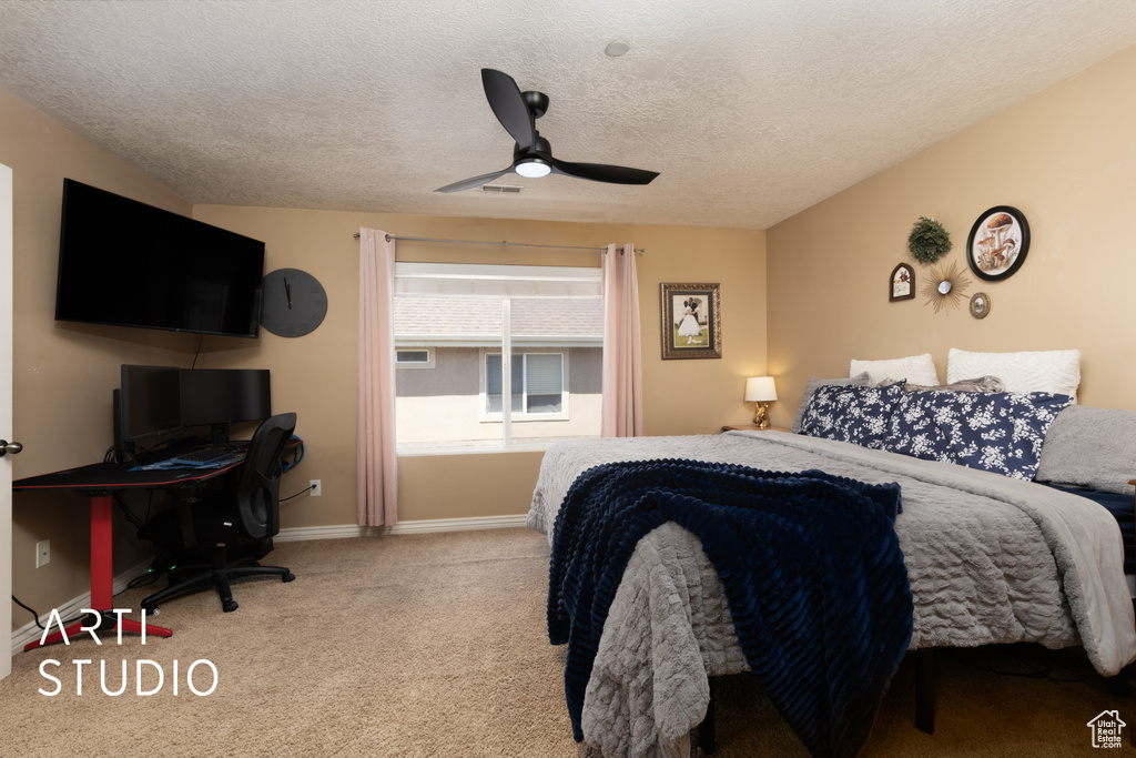 Bedroom with an office area, carpet, a ceiling fan, a textured ceiling, and baseboards