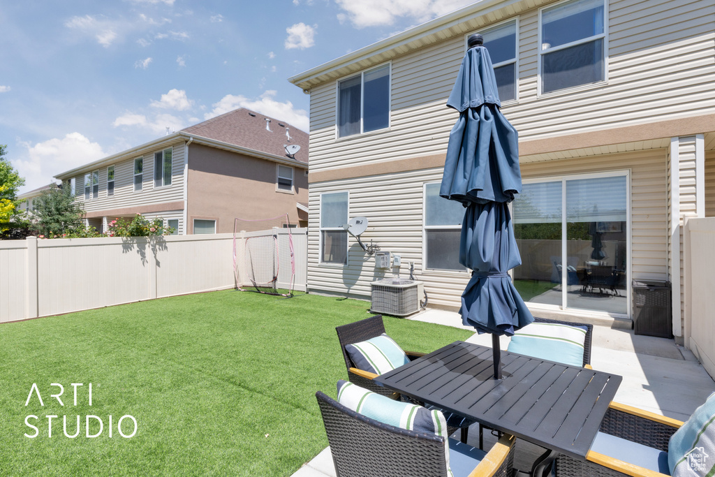 View of yard featuring outdoor dining area, a patio area, and central AC