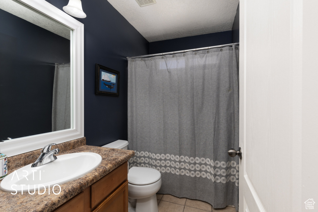Full bath featuring toilet, vanity, and tile patterned floors