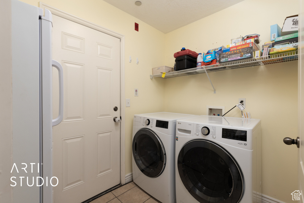 Washroom featuring washing machine and dryer and light tile patterned floors