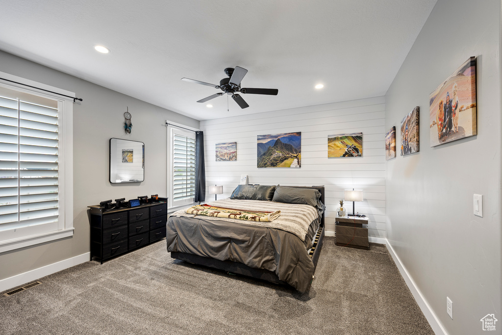 Bedroom featuring recessed lighting, baseboards, carpet flooring, a ceiling fan, and wooden walls