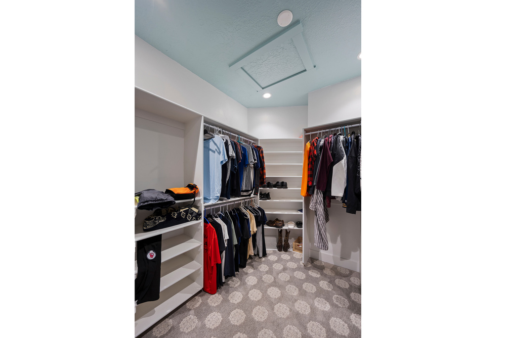 Spacious closet with attic access and carpet flooring