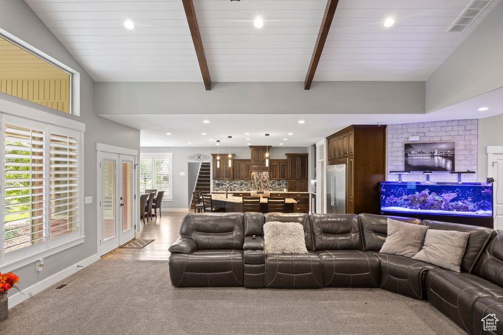Living room with recessed lighting, baseboards, beam ceiling, and light colored carpet