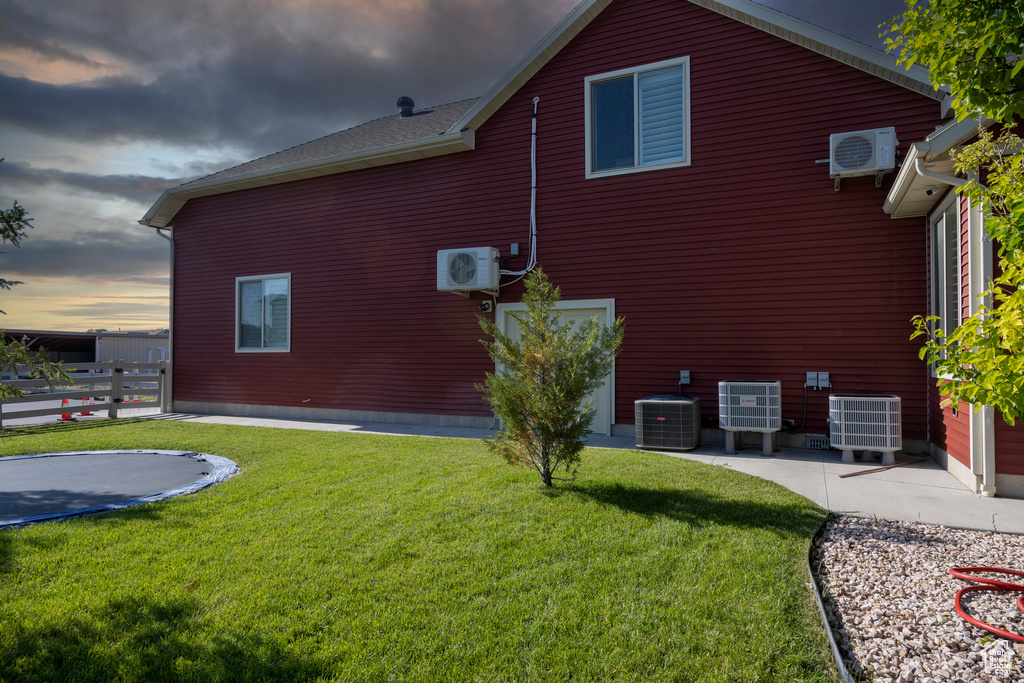 View of property exterior with central AC, a trampoline, and a cooling unit