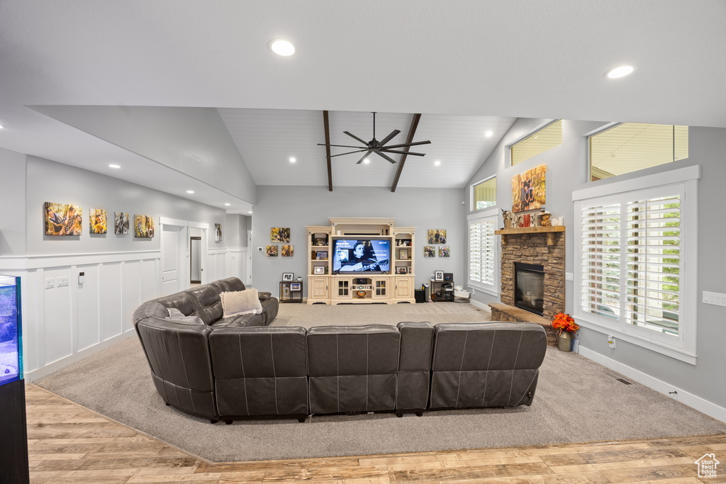 Living room with ceiling fan, a stone fireplace, wood finished floors, recessed lighting, and baseboards