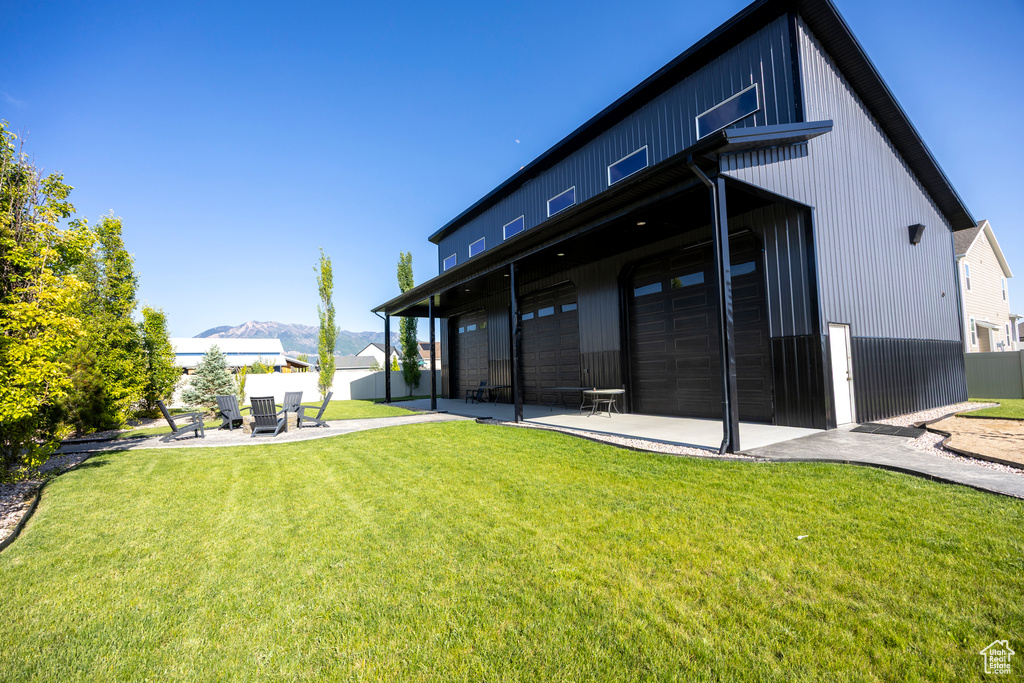 Rear view of property with a mountain view, a patio, and an attached garage