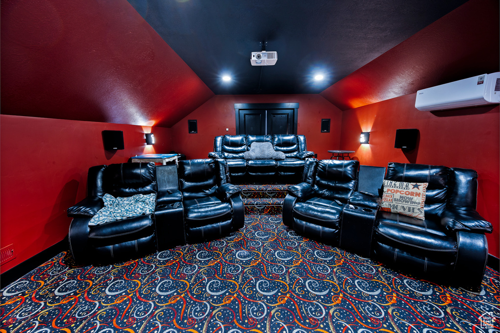 Carpeted cinema with a wall mounted AC, vaulted ceiling, and baseboards