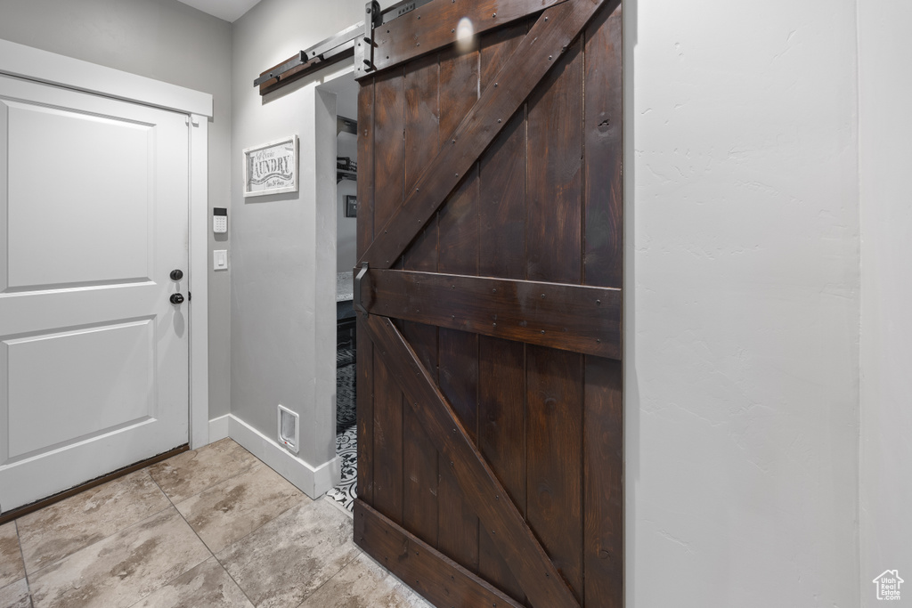 Foyer featuring a barn door and baseboards