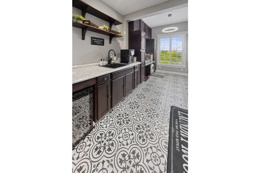 Indoor wet bar with tile patterned floors and baseboards