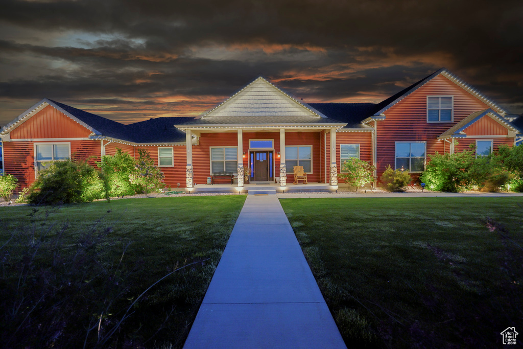View of front of property featuring covered porch and a front lawn