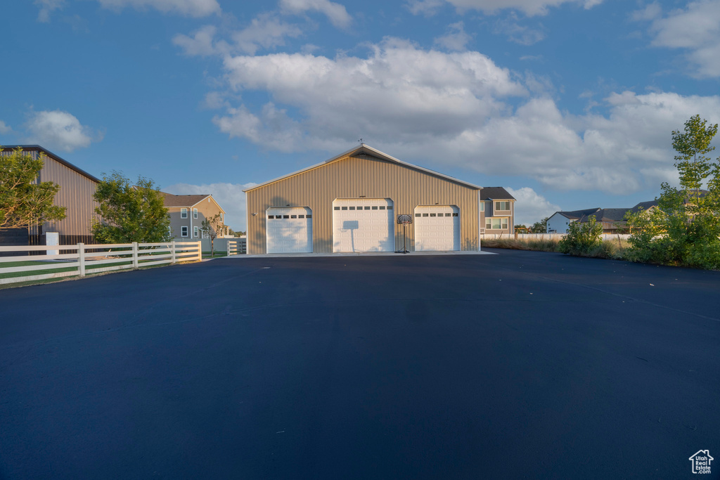 View of front of property with a detached garage and an outbuilding