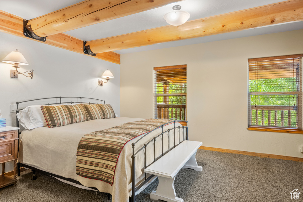 Bedroom with carpet, beam ceiling, and baseboards