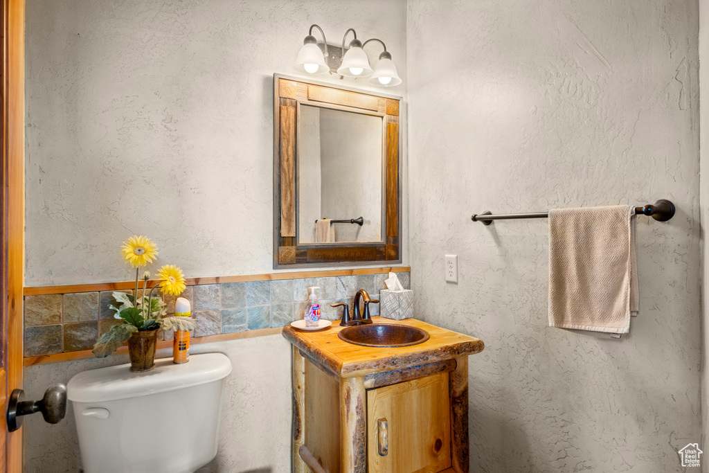 Half bath featuring toilet and vanity