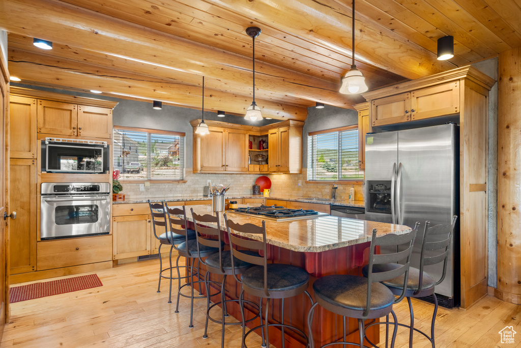 Kitchen with appliances with stainless steel finishes, light wood-style flooring, light stone countertops, decorative backsplash, and wood ceiling