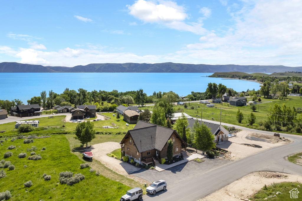 Aerial view of property and surrounding area featuring a water and mountain view