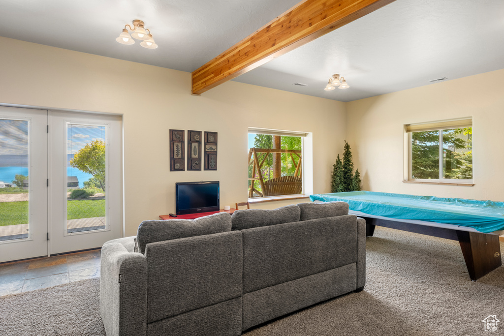 Living area featuring beamed ceiling and stone tile floors