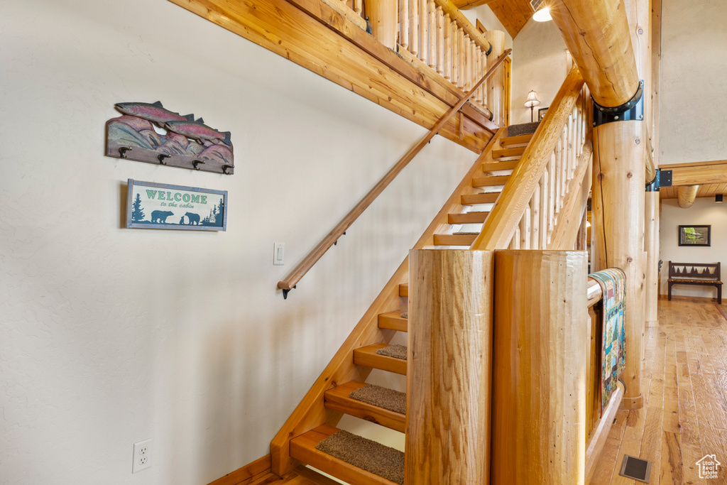 Stairway featuring wood-type flooring and a towering ceiling