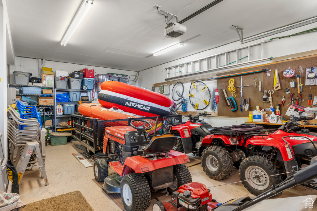 Garage featuring a garage door opener and a workshop area