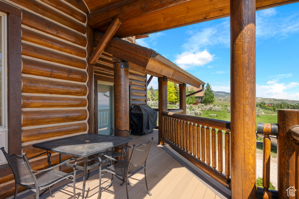 Deck with area for grilling, a mountain view, and outdoor dining area