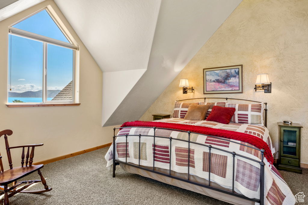 Bedroom with carpet floors, vaulted ceiling, baseboards, and a water view