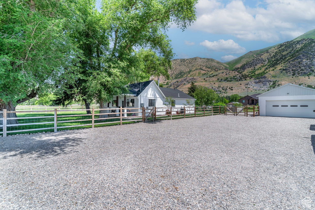 View of front facade with a garage, a mountain view, and an outdoor structure