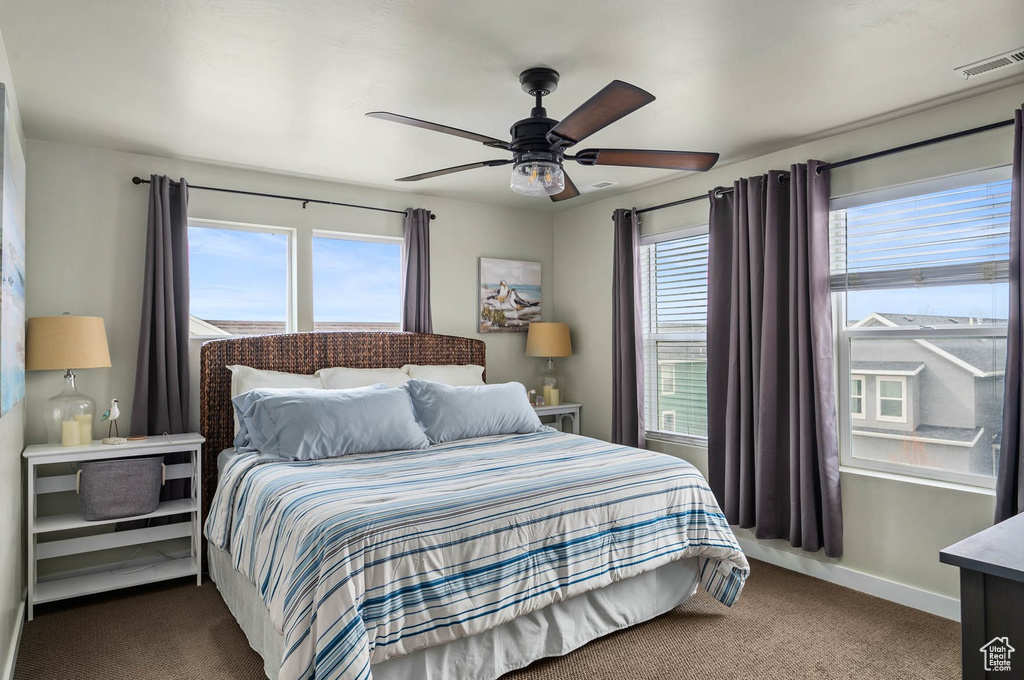 Carpeted bedroom with ceiling fan and baseboards