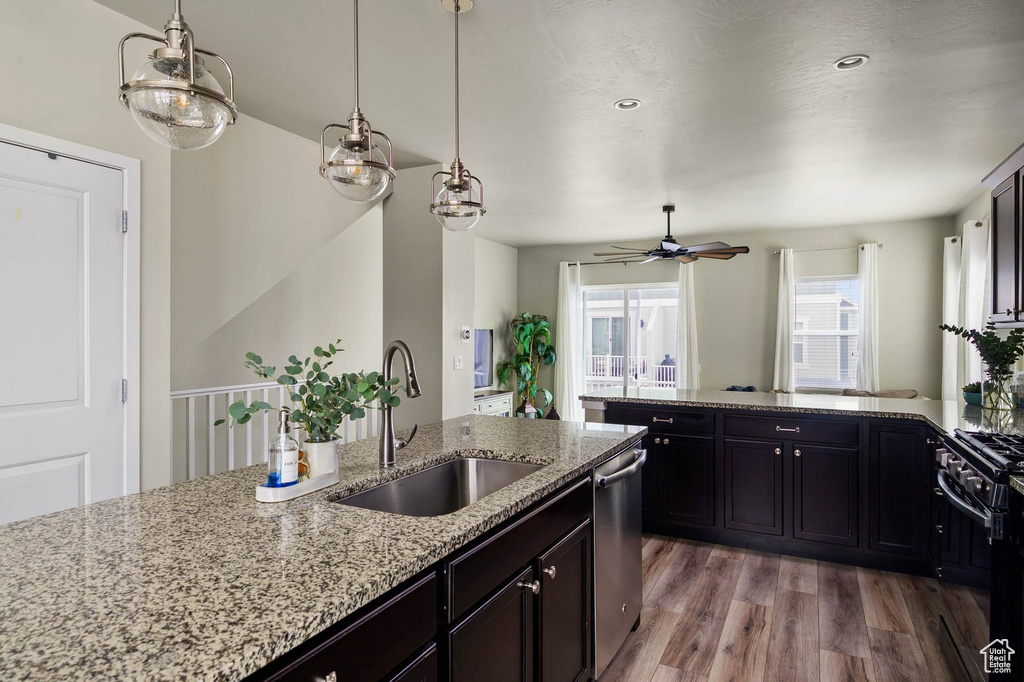 Kitchen with a sink, dishwasher, light wood-style flooring, black range with gas stovetop, and a ceiling fan