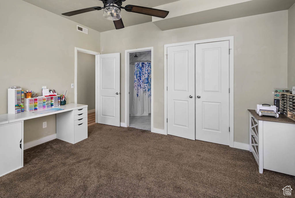 Office featuring dark carpet, a ceiling fan, and baseboards