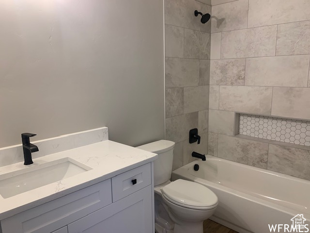 Bathroom with toilet, tub / shower combination, and vanity