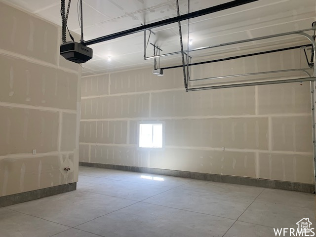 Garage with a garage door opener and baseboards