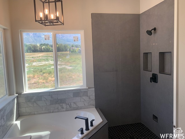 Full bathroom featuring a bath, tiled shower, and healthy amount of natural light