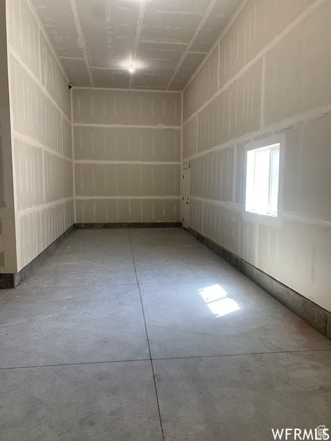 Spare room featuring unfinished concrete flooring