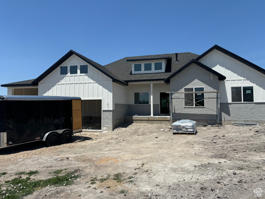 View of front of house featuring roof with shingles, board and batten siding, and an attached garage