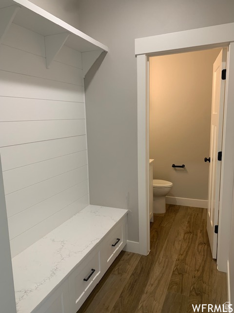Mudroom with dark wood finished floors and baseboards
