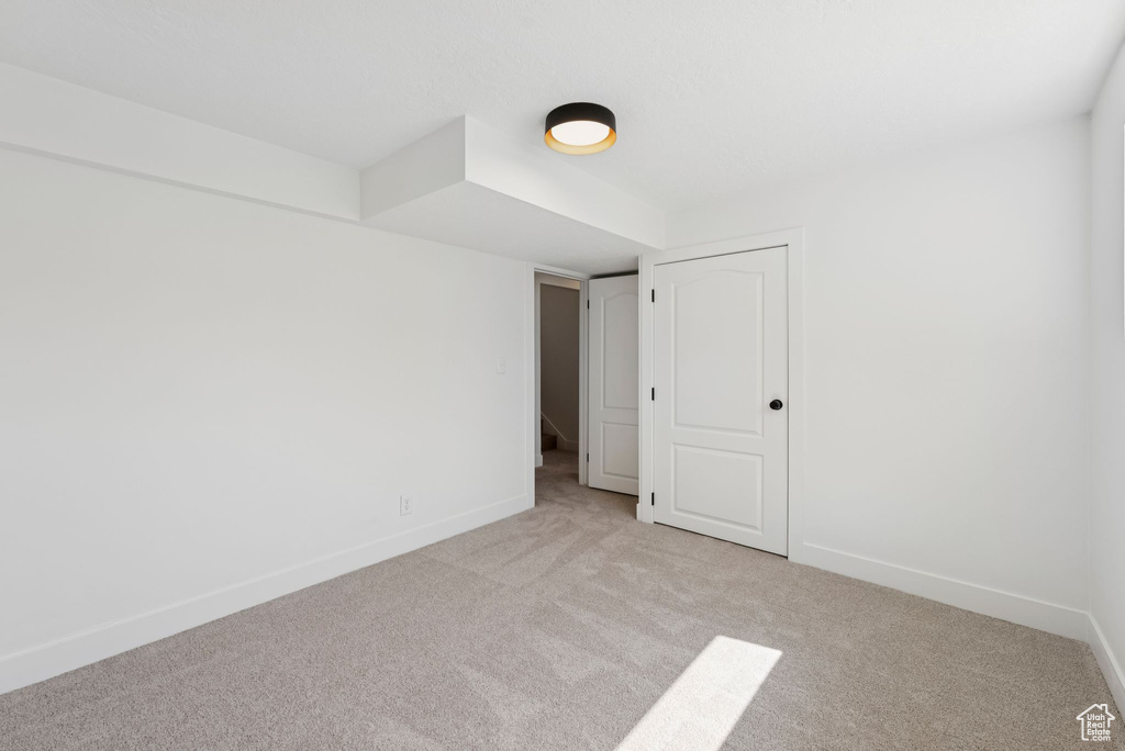 Empty room featuring carpet flooring and baseboards