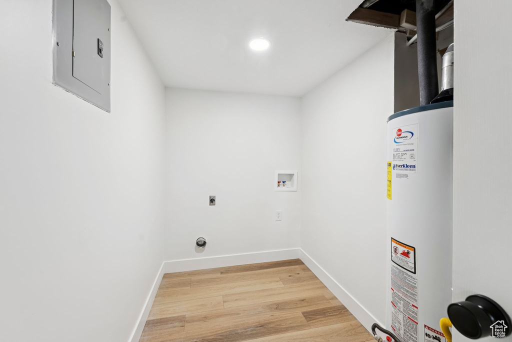 Laundry room with electric panel, electric dryer hookup, gas water heater, washer hookup, and light wood-style flooring