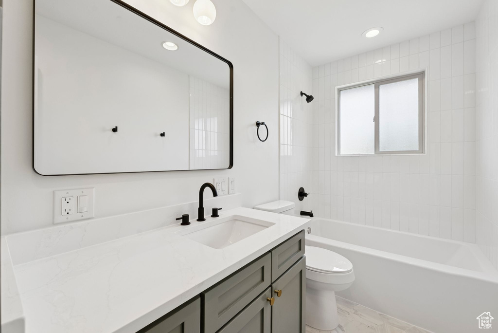 Full bathroom featuring toilet, vanity, shower / tub combination, marble finish floors, and recessed lighting