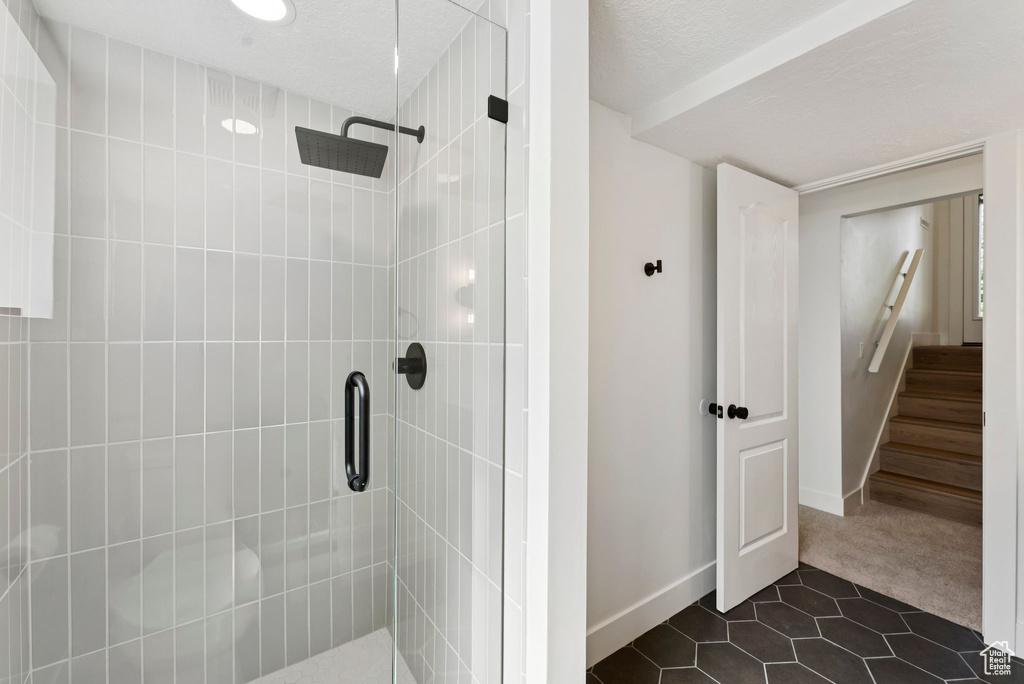 Bathroom featuring a shower stall, tile patterned floors, and baseboards