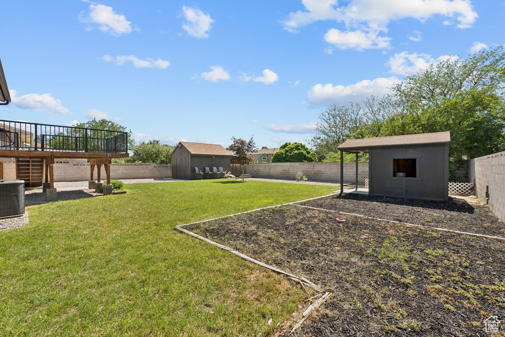 View of yard featuring a wooden deck and central AC