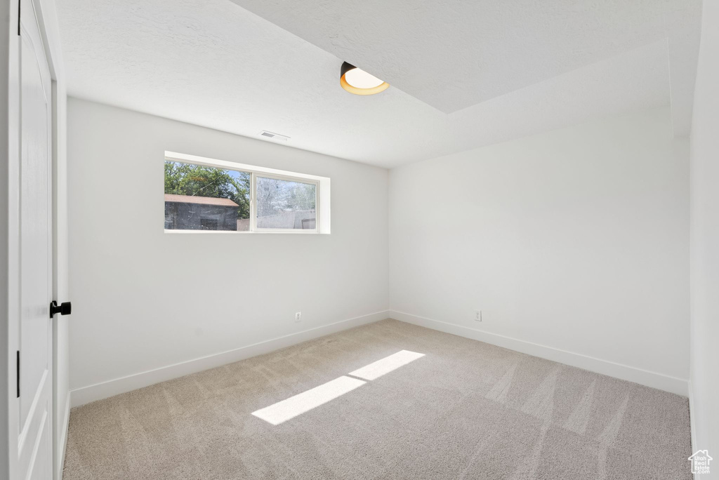 Carpeted spare room featuring baseboards