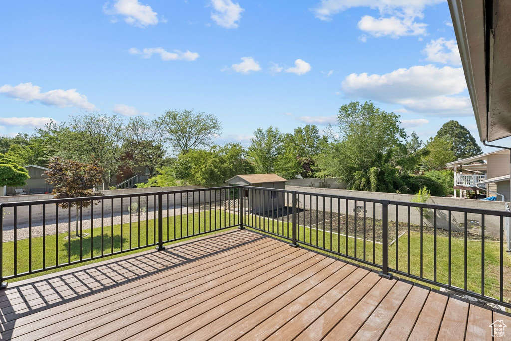 Deck with a lawn and view of wooded area