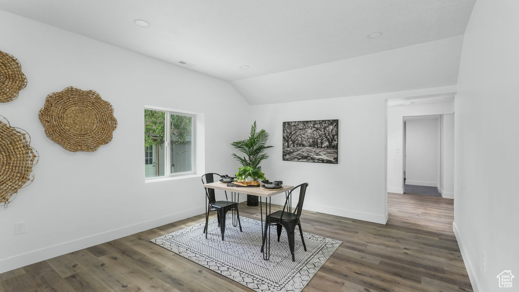 Dining area with wood finished floors, lofted ceiling, baseboards, and recessed lighting