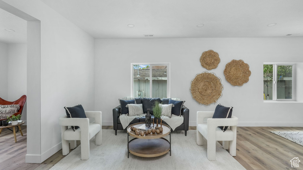 Sitting room with wood finished floors, plenty of natural light, baseboards, and recessed lighting