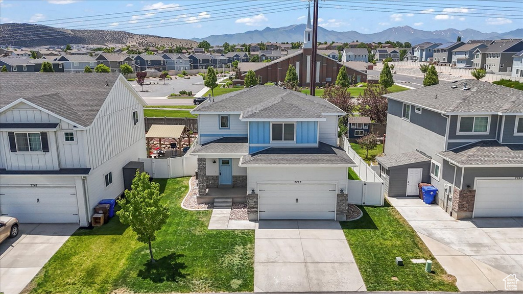 View of front facade with a residential view, a garage, and a mountain view